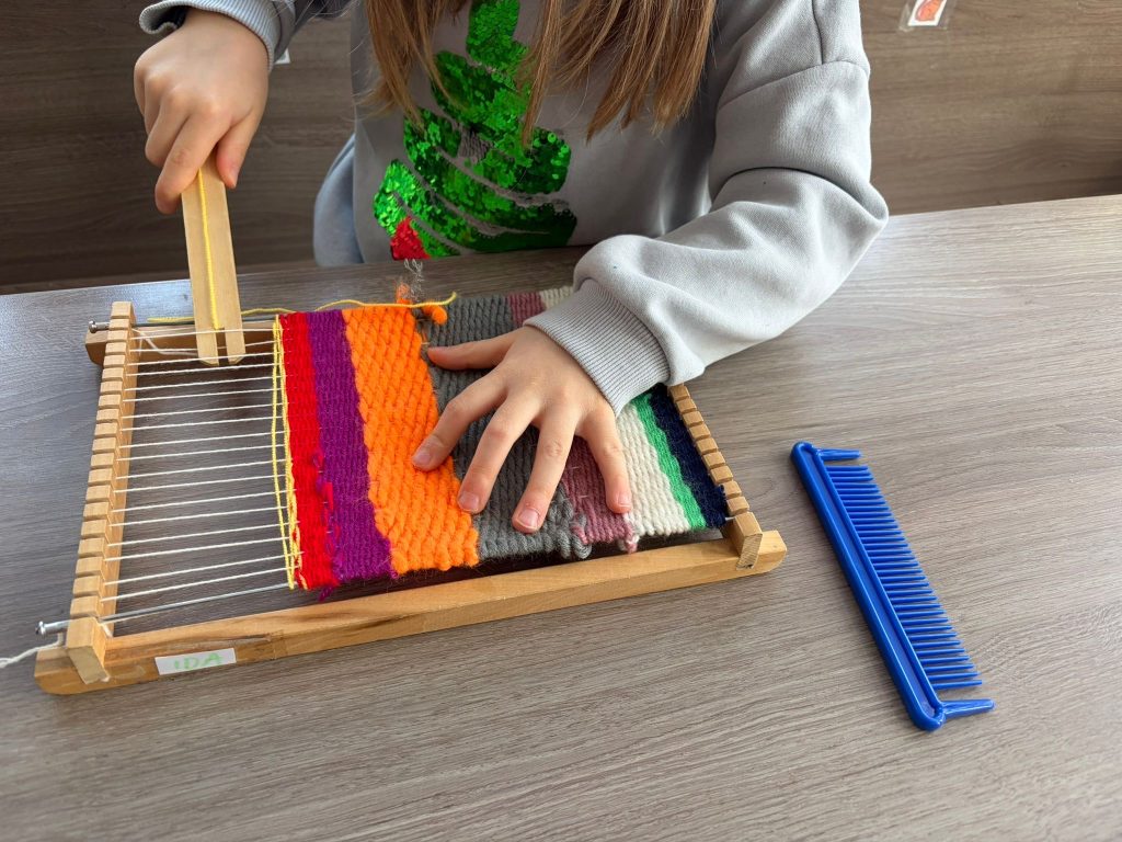 Freies Spielen - Kind webt am Webrahmen